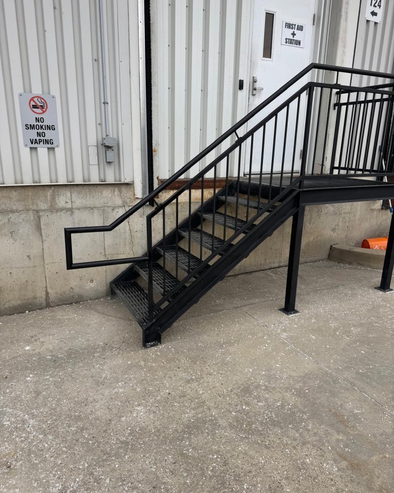 Industrial 42-inch steel guardrail with mid-rail and kick-plate installed at the edge of a mezzanine in an Ontario warehouse