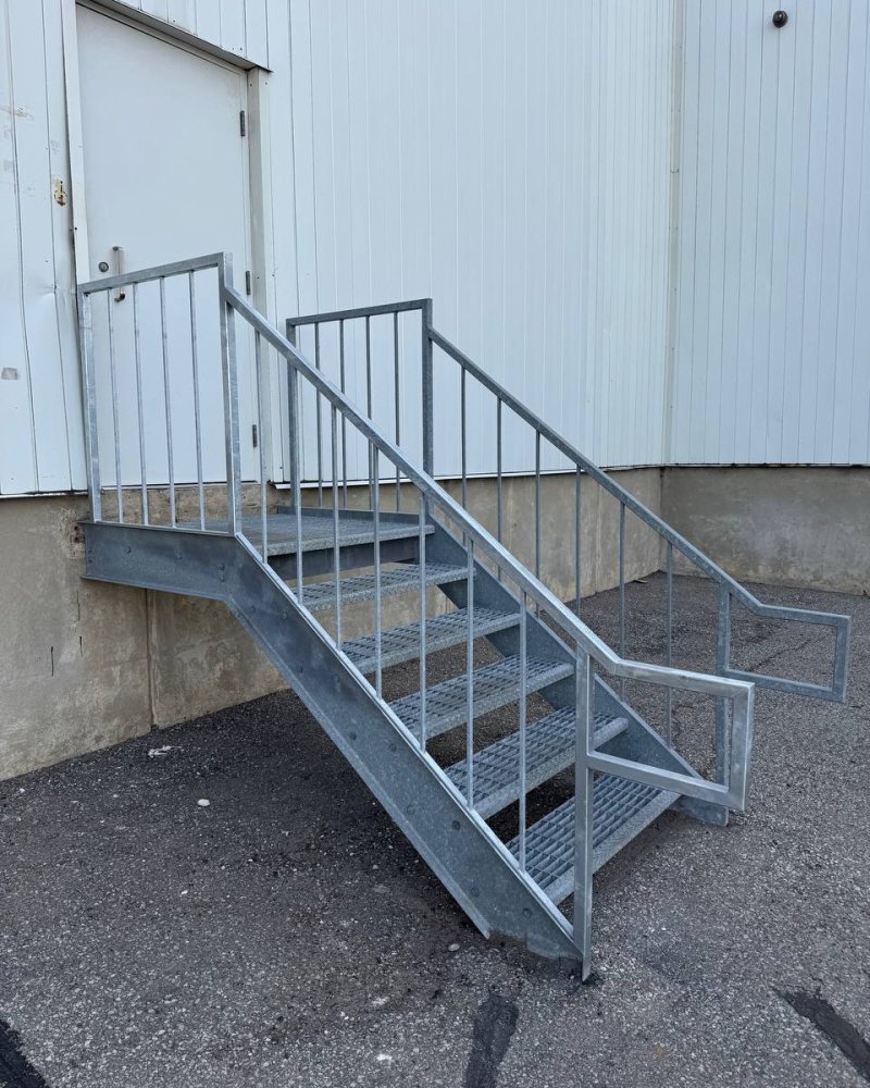 Galvanized outdoor steel stairs serving a rooftop mechanical platform on an Ontario industrial building