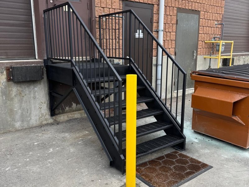 Brampton fulfillment facility — 18 ft exterior stair tower retrofit for code compliance, galvanized, with crossover platform.