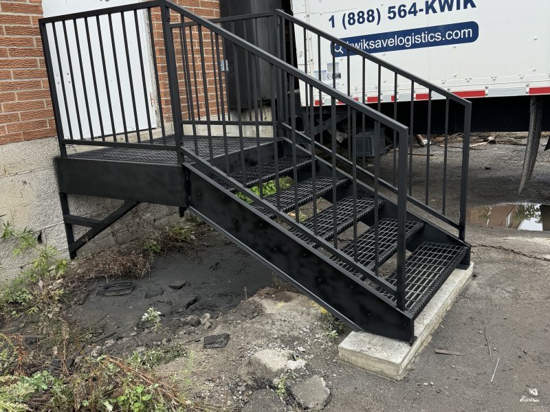 Ship's ladder to mezzanine — Grip-strut treads, pivot-arm rail
